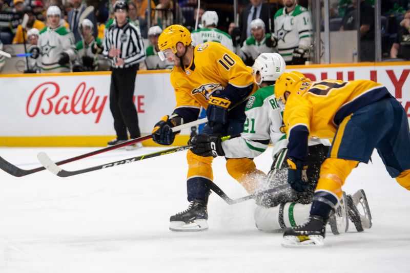 Feb 15, 2024; Nashville, Tennessee, USA; Dallas Stars left wing Jason Robertson (21) gets pinned between Nashville Predators center Colton Sissons (10) and defenseman Alexandre Carrier (45) during the second period at Bridgestone Arena. Mandatory Credit: Steve Roberts-USA TODAY Sports