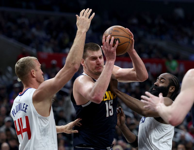 LOS ANGELES, CALIFORNIA - APRIL 04: Nikola Jokic #15 of the Denver Nuggets reacts as he is trapped by Mason Plumlee #44 of the LA Clippers and James Harden #1 during a 102-100 Clippers win at Crypto.com Arena on April 04, 2024 in Los Angeles, California. User is consenting to the terms and conditions of the Getty Images License Agreement. (Photo by Harry How/Getty Images)