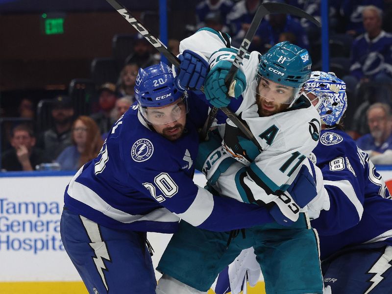 Dec 5, 2024; Tampa, Florida, USA; Tampa Bay Lightning left wing Nick Paul (20) and San Jose Sharks center Luke Kunin (11) fight to control the puck during the second period at Amalie Arena. Mandatory Credit: Kim Klement Neitzel-Imagn Images