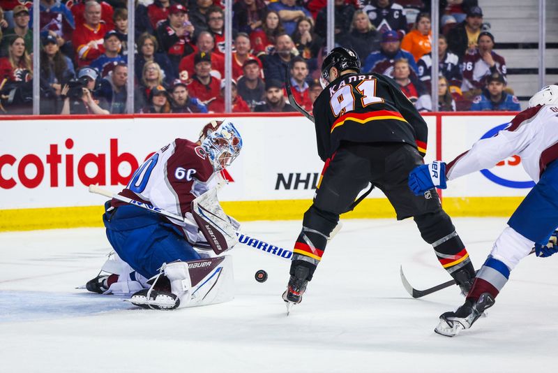 Mar 12, 2024; Calgary, Alberta, CAN; Colorado Avalanche goaltender Justus Annunen (60) makes a save against Calgary Flames center Nazem Kadri (91) during the second period at Scotiabank Saddledome. Mandatory Credit: Sergei Belski-USA TODAY Sports