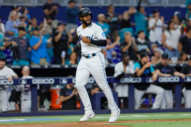 Jun 4, 2023; Miami, Florida, USA; Miami Marlins left fielder Bryan De La Cruz (14) scores after a three-run home run by designated hitter Garrett Cooper (not pictured) against the Oakland Athletics during the fifth inning at loanDepot Park. Mandatory Credit: Sam Navarro-USA TODAY Sports