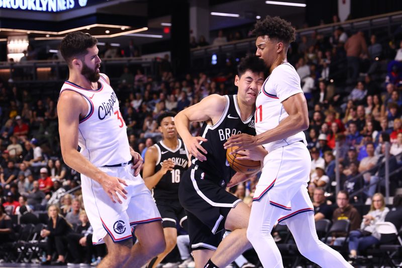 OCEANSIDE, CALIFORNIA - OCTOBER 08: Yongxi Cui of the Brooklyn Nets collides with Jordan Miller #11 of the Los Angeles Clippers in the fourth quarter of a preseason game at Frontwave Arena on October 08, 2024 in Oceanside, California. NOTE TO USER: User expressly acknowledges and agrees that, by downloading and or using this photograph, User is consenting to the terms and conditions of the Getty Images License Agreement. (Photo by Joe Scarnici/Getty Images)