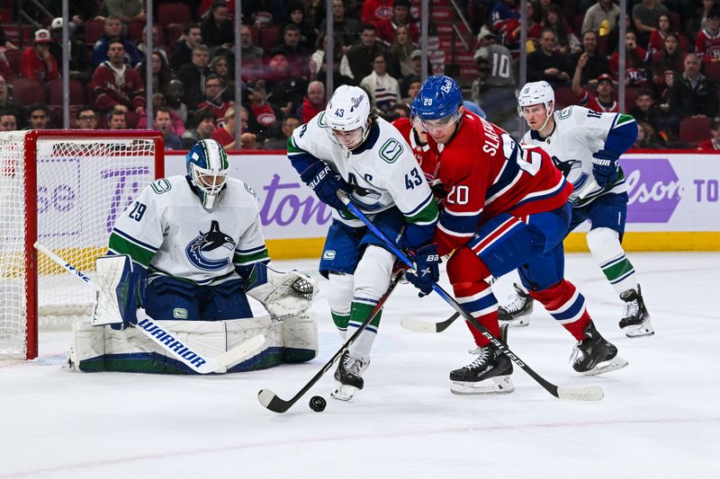 Nov 12, 2023; Montreal, Quebec, CAN; Vancouver Canucks defenseman Quinn Hughes (43) defends the puck against Montreal Canadiens left wing Juraj Slafkovsky (20) during the second period at Bell Centre. Mandatory Credit: David Kirouac-USA TODAY Sports