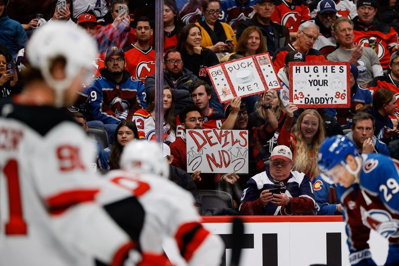 Feb 26, 2025; Denver, Colorado, USA; New Jersey Devils fans hold up signs in the second period against the Colorado Avalanche at Ball Arena. Mandatory Credit: Isaiah J. Downing-Imagn Images