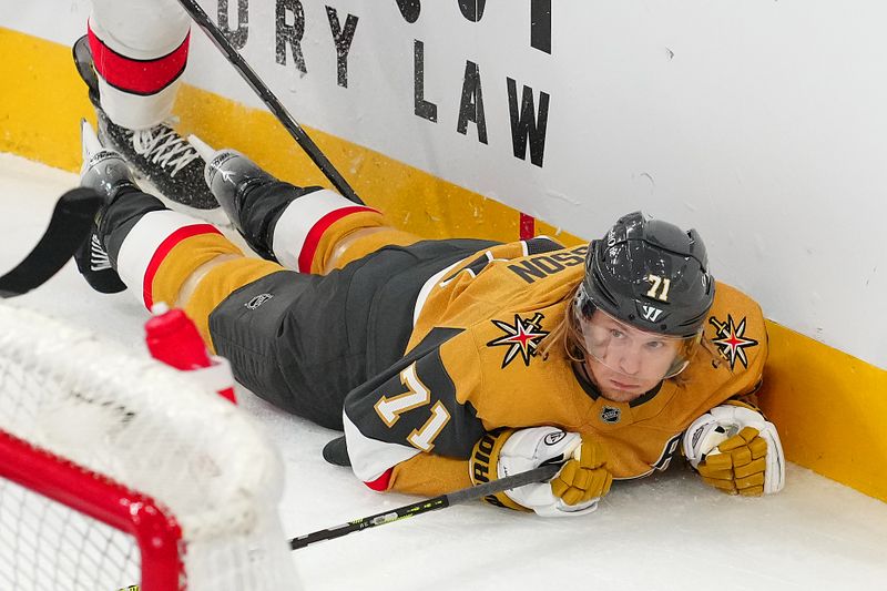 Nov 11, 2024; Las Vegas, Nevada, USA; Vegas Golden Knights center William Karlsson (71) is checked to the ice by Carolina Hurricanes defenseman Shayne Gostisbehere (4) during the third period at T-Mobile Arena. Mandatory Credit: Stephen R. Sylvanie-Imagn Images