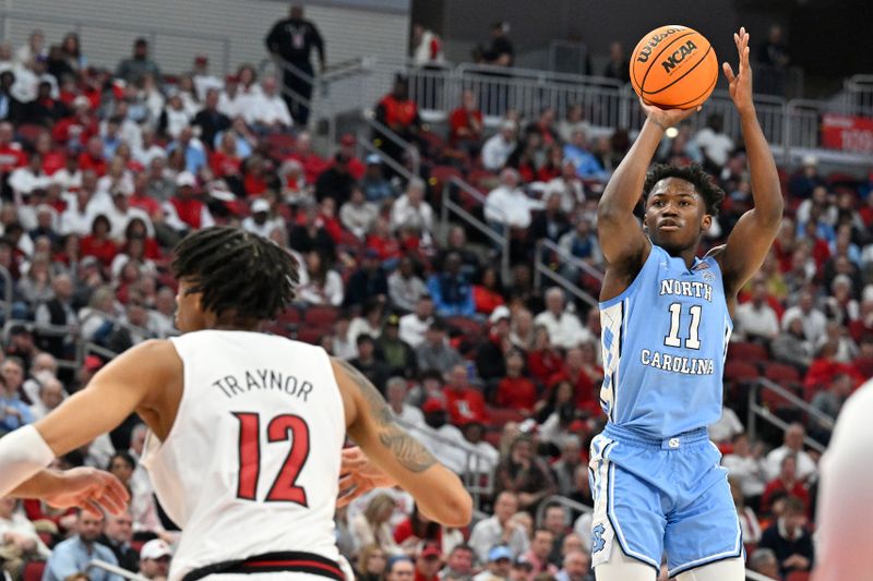 Jan 14, 2023; Louisville, Kentucky, USA;  North Carolina Tar Heels guard D'Marco Dunn (11) shoots the ball against Louisville Cardinals forward JJ Traynor (12) during the first half at KFC Yum! Center. Mandatory Credit: Jamie Rhodes-USA TODAY Sports