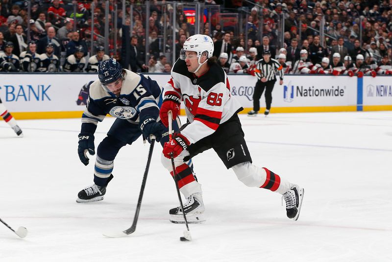Dec 31, 2025; Columbus, Ohio, USA; New Jersey Devils center Jack Hughes (86) wrists a shot on goal as Columbus Blue Jackets defenseman Dante Fabbro (15) defends during the first period at Nationwide Arena. Mandatory Credit: Russell LaBounty-Imagn Images