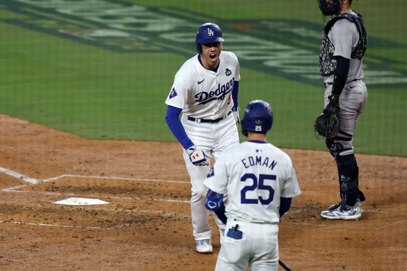 Oct 26, 2024; Los Angeles, California, USA; Los Angeles Dodgers first baseman Freddie Freeman (5) reacts with shortstop Tommy Edman (25) after hitting a home run against the New York Yankees in the third inning for game two of the 2024 MLB World Series at Dodger Stadium. Mandatory Credit: Kiyoshi Mio-Imagn Images