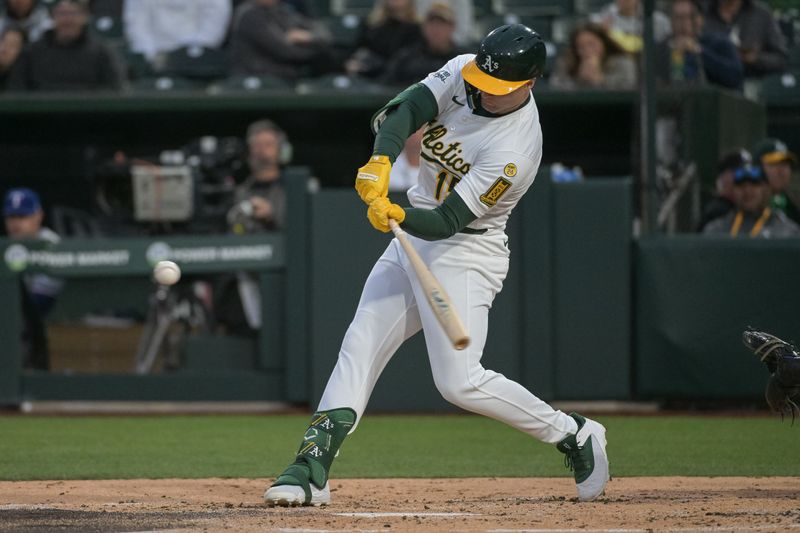Apr 24, 2025; West Sacramento, California, USA; Athletics outfielder Seth Brown (15) hits a double against the Texas Rangers during the second inning at Sutter Health Park. Mandatory Credit: Ed Szczepanski-Imagn Images