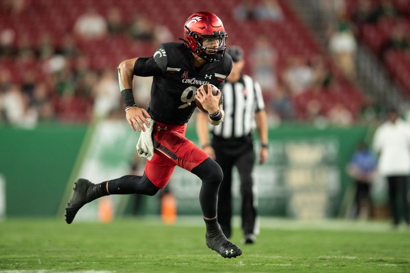 Nov 12, 2021; Tampa, Florida, USA; Cincinnati Bearcats quarterback Desmond Ridder (9) runs with the ball in the 3rd quarter against the South Florida Bulls at Raymond James Stadium. Mandatory Credit: Jeremy Reper-USA TODAY Sports