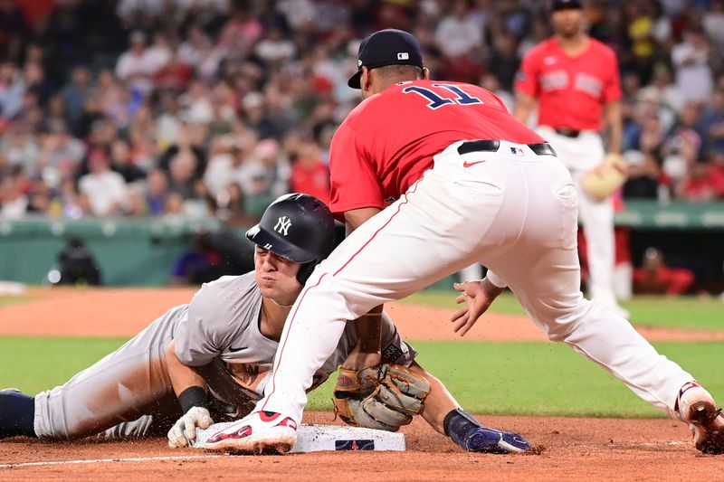 Jun 14, 2024; Boston, Massachusetts, USA; New York Yankees shortstop Anthony Volpe (11) steals third base  against Boston Red Sox third baseman Rafael Devers (11) during the fifth inning at Fenway Park. Mandatory Credit: Eric Canha-USA TODAY Sports