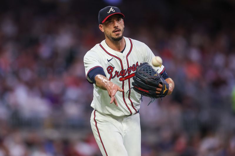 Aug 1, 2024; Atlanta, Georgia, USA; Atlanta Braves starting pitcher Charlie Morton (50) tosses a ball to first against the Miami Marlins in the fifth inning at Truist Park. Mandatory Credit: Brett Davis-USA TODAY Sports
