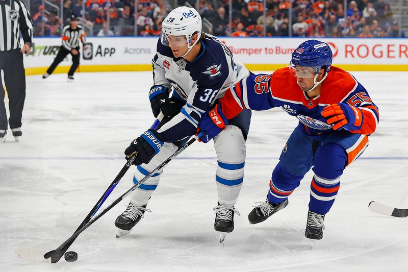 Sep 26, 2025; Edmonton, Alberta, CAN; Winnipeg Jets forward Morgan Barron (36) and Edmonton Oilers defensemen Cam Dineen (55) battle for a loose puck during the second period at Rogers Place. Mandatory Credit: Perry Nelson-Imagn Images
