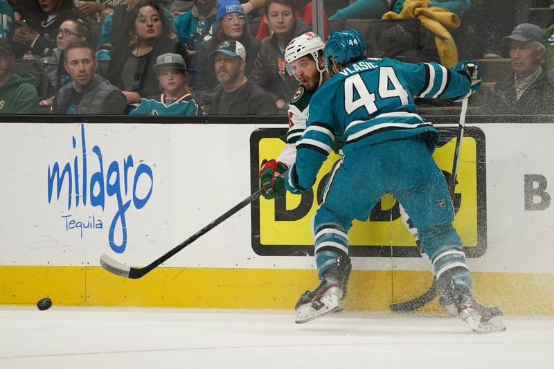 Apr 13, 2024; San Jose, California, USA; Minnesota Wild right wing Ryan Hartman (38) is defended by San Jose Sharks defenseman Marc-Edouard Vlasic (44) during the first period at SAP Center at San Jose. Mandatory Credit: David Gonzales-USA TODAY Sports