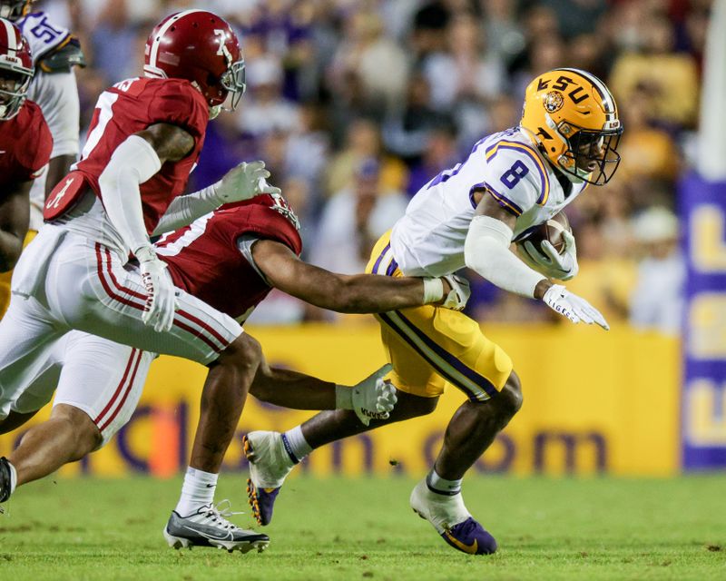 Nov 5, 2022; Baton Rouge, Louisiana, USA; LSU Tigers wide receiver Malik Nabers (8) is is tackled by the Alabama Crimson Tide during the second half at Tiger Stadium. Mandatory Credit: Stephen Lew-USA TODAY Sports