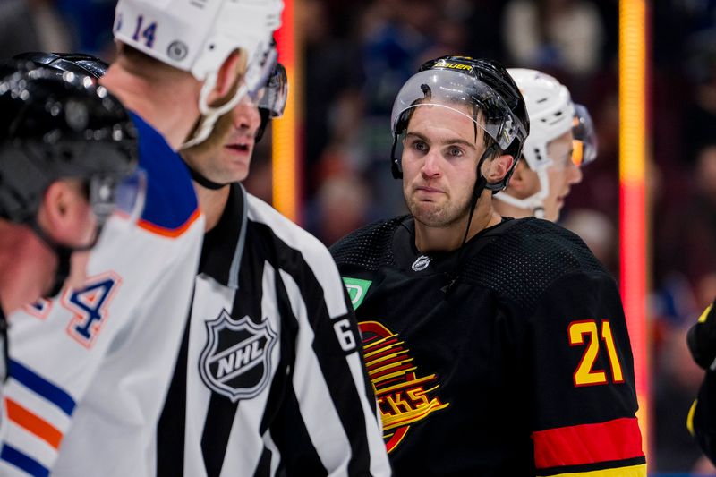 Nov 6, 2023; Vancouver, British Columbia, CAN; Vancouver Canucks forward Nils Hoglander (21) reacts after wrestling with Edmonton Oilers defenseman Mattias Ekholm (14) in the first period at Rogers Arena. Mandatory Credit: Bob Frid-USA TODAY Sports