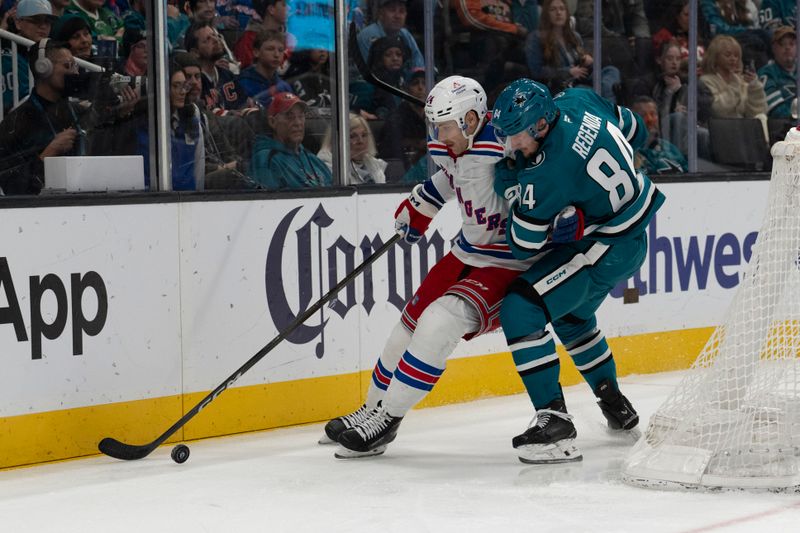 Jan 23, 2026; San Jose, California, USA;  New York Rangers defenseman Carson Soucy (24) and San Jose Sharks left wing Pavol Regenda (84) fight for control of the puck during the second period at SAP Center at San Jose. Mandatory Credit: Stan Szeto-Imagn Images