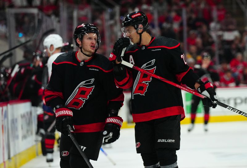 Apr 20, 2024; Raleigh, North Carolina, USA; Carolina Hurricanes center Sebastian Aho (20) and Carolina Hurricanes center Jake Guentzel (59) talk against the New York Islanders during the first period in game one of the first round of the 2024 Stanley Cup Playoffs at PNC Arena. Mandatory Credit: James Guillory-USA TODAY Sports