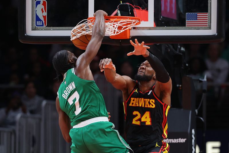 ATLANTA, GEORGIA - MARCH 28:  Jaylen Brown #7 of the Boston Celtics dunks over Bruno Fernando #24 of the Atlanta Hawks during third quarter at State Farm Arena on March 28, 2024 in Atlanta, Georgia.  NOTE TO USER: User expressly acknowledges and agrees that, by downloading and/or using this photograph, user is consenting to the terms and conditions of the Getty Images License Agreement.  (Photo by Kevin C. Cox/Getty Images)