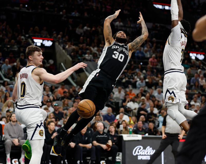 SAN ANTONIO, TX - APRIL 12: Julian Champagne #30 of the San Antonio Spurs is stripped of the ball by Christian Braun #0 of the Denver Nuggets in the first half at Frost Bank Center on April 12, 2024 in San Antonio, Texas. NOTE TO USER: User expressly acknowledges and agrees that, by downloading and or using this photograph, User is consenting to terms and conditions of the Getty Images License Agreement. (Photo by Ronald Cortes/Getty Images)