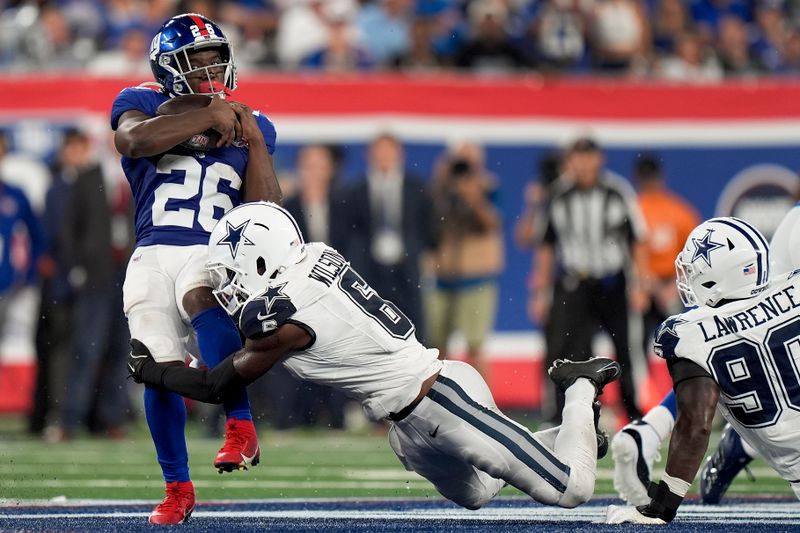 New York Giants running back Devin Singletary (26) is tackled by Dallas Cowboys safety Donovan Wilson (6) during the second quarter of an NFL football game, Thursday, Sept. 26, 2024, in East Rutherford, N.J. (AP Photo/Bryan Woolston)