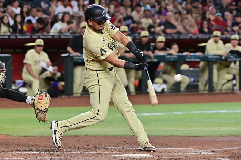 Jun 4, 2024; Phoenix, Arizona, USA;  Arizona Diamondbacks catcher Gabriel Moreno (14) hits a sacrifice fly in the third inning against the San Francisco Giants at Chase Field. Mandatory Credit: Matt Kartozian-USA TODAY Sports