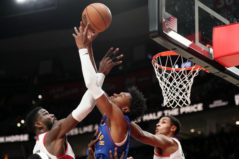 PORTLAND, OREGON - FEBRUARY 23: Deandre Ayton #2, left, and Kris Murray #8, right, of the Portland Trail Blazers, and Peyton Watson #8, center, of the Denver Nuggets grab for a rebound during the fourth quarter at Moda Center on February 23, 2024 in Portland, Oregon. NOTE TO USER: User expressly acknowledges and agrees that, by downloading and or using this photograph, User is consenting to the terms and conditions of the Getty Images License Agreement.? (Photo by Amanda Loman/Getty Images)