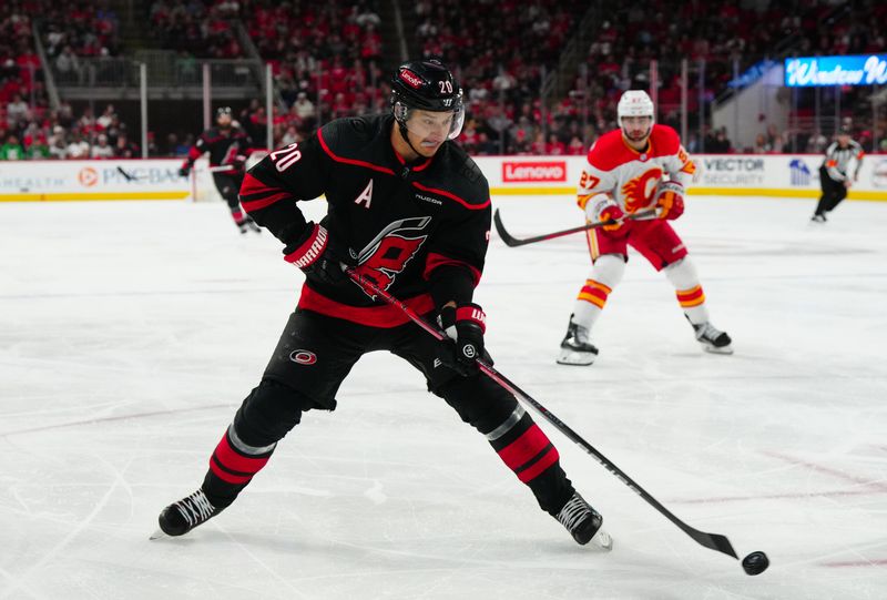 Mar 10, 2024; Raleigh, North Carolina, USA;  Carolina Hurricanes center Sebastian Aho (20) takes a back hand shot against the Calgary Flames during the third period at PNC Arena. Mandatory Credit: James Guillory-USA TODAY Sports