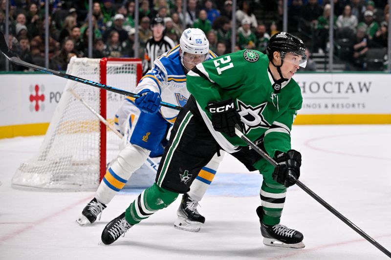 Jan 23, 2026; Dallas, Texas, USA; Dallas Stars left wing Jason Robertson (21) keeps the puck away from St. Louis Blues defenseman Colton Parayko (55) during the second period at the American Airlines Center. Mandatory Credit: Jerome Miron-Imagn Images