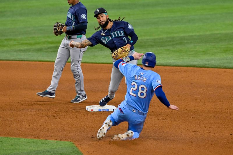 Sep 22, 2024; Arlington, Texas, USA; Seattle Mariners shortstop J.P. Crawford (3) puts out Texas Rangers catcher Jonah Heim (28) on a double play at second base during the fifth inning at Globe Life Field. Mandatory Credit: Jerome Miron-Imagn Images