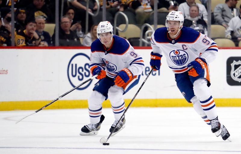 Feb 23, 2023; Pittsburgh, Pennsylvania, USA;  Edmonton Oilers center Connor McDavid (97) and center Ryan Nugent-Hopkins (93) skate up ice with the puck against the Pittsburgh Penguins during the third period at PPG Paints Arena. Edmonton won 7-2. Mandatory Credit: Charles LeClaire-USA TODAY Sports