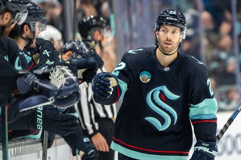 Nov 8, 2024; Seattle, Washington, USA;  Seattle Kraken forward Oliver Bjorkstrand (22) is congratulated by teammates on the bench after scoring a goal during the third period against the Vegas Golden Knights at Climate Pledge Arena. Mandatory Credit: Stephen Brashear-Imagn Images