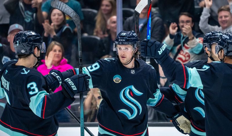 Oct 22, 2024; Seattle, Washington, USA;  Seattle Kraken forward Jared McCann (19), center, celebrates scoring a goal with defenseman Will Borgen (3) and forward Jordan Eberle (7) during the second period against the Colorado Avalanche at Climate Pledge Arena. Mandatory Credit: Stephen Brashear-Imagn Images