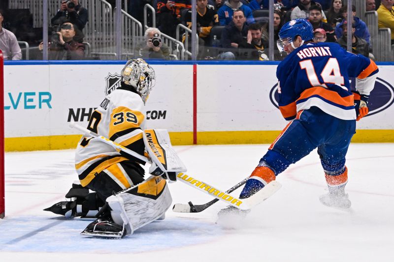 Apr 17, 2024; Elmont, New York, USA;  Pittsburgh Penguins goaltender Alex Nedeljkovic (39) makes a save on New York Islanders center Bo Horvat (14) during the second period at UBS Arena. Mandatory Credit: Dennis Schneidler-USA TODAY Sports