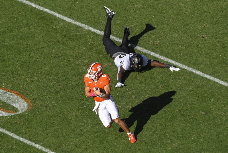 Oct 7, 2023; Clemson, South Carolina, USA; Clemson quarterback Cade Klubnik (2) runs by Wake Forest defensive lineman Jasheen Davis (30) during the second quarter at Memorial Stadium. Mandatory Credit: Ken Ruinard-USA TODAY Sports