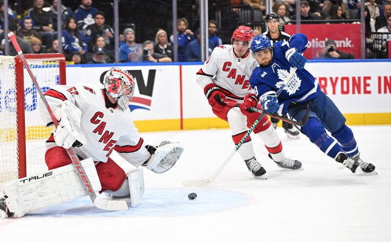 Dec 30, 2023; Toronto, Ontario, CAN; Carolina Hurricanes goalie Pyotr Kochetkov (52) makes a save as defenseman Brady Skjei (76) covers Toronto Maple Leafs forward William Nylander (88) in the first period at Scotiabank Arena. Mandatory Credit: Dan Hamilton-USA TODAY Sports