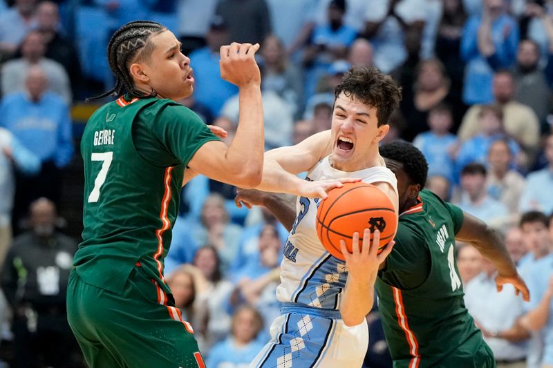 Feb 26, 2024; Chapel Hill, North Carolina, USA; North Carolina Tar Heels guard Cormac Ryan (3) with the ball as Miami (Fl) Hurricanes guards Kyshawn George (7) and  Bensley Joseph (4) defend in the second half at Dean E. Smith Center. Mandatory Credit: Bob Donnan-USA TODAY Sports