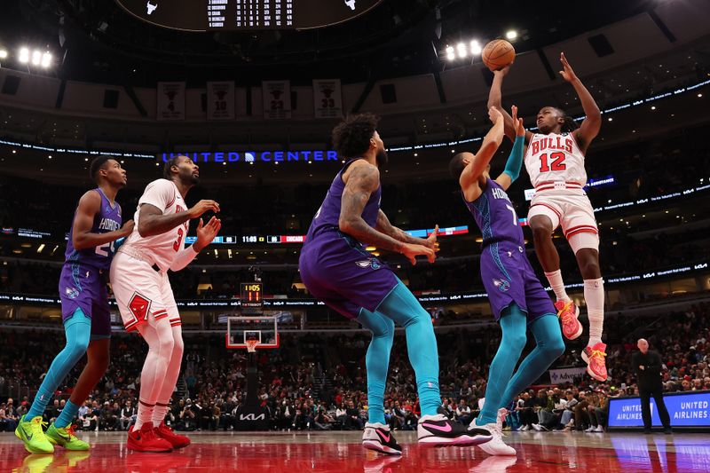 CHICAGO, ILLINOIS - DECEMBER 06: Ayo Dosunmu #12 of the Chicago Bulls shoots against the Charlotte Hornets during the second half at the United Center on December 06, 2023 in Chicago, Illinois. NOTE TO USER: User expressly acknowledges and agrees that, by downloading and or using this photograph, User is consenting to the terms and conditions of the Getty Images License Agreement.  (Photo by Michael Reaves/Getty Images)