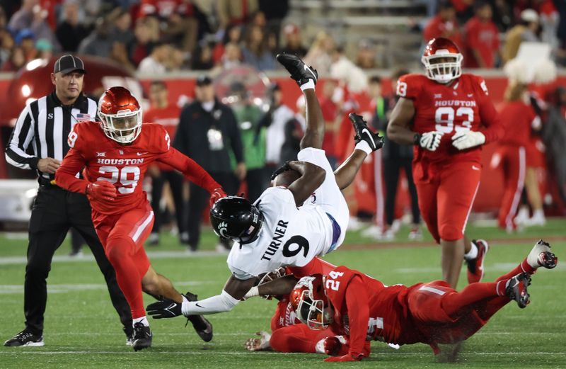 Nov 11, 2023; Houston, Texas, USA; Cincinnati Bearcats wide receiver Aaron Turner (9) is tackled. By Houston Cougars defensive back Adari Haulcy (24) and linebacker Jamal Morris (25)  in the second half at TDECU Stadium. Mandatory Credit: Thomas Shea-USA TODAY Sports