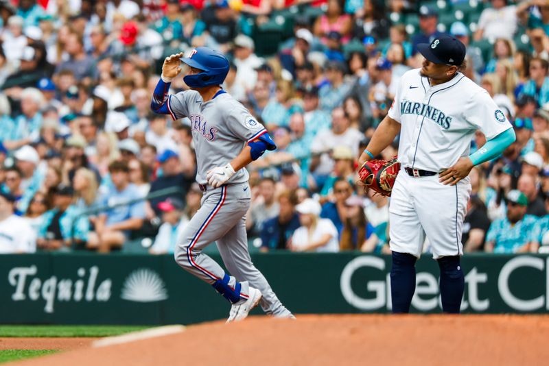 Aug 2, 2025; Seattle, Washington, USA; Texas Rangers catcher Kyle Higashioka (11) runs the bases past Seattle Mariners first baseman Josh Naylor (12) after hitting a two-run home run during the third inning at T-Mobile Park. Mandatory Credit: Joe Nicholson-Imagn Images