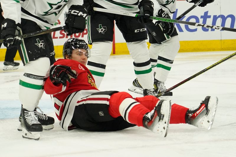 Nov 27, 2024; Chicago, Illinois, USA; Chicago Blackhawks center Connor Bedard (98) is knocked to the ice against the Dallas Stars during the third period at United Center. Mandatory Credit: David Banks-Imagn Images