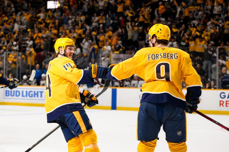 Nov 2, 2024; Nashville, Tennessee, USA;  Nashville Predators center Gustav Nyquist (14) celebrates the goal of left wing Filip Forsberg (9) against the Colorado Avalanche during the third period at Bridgestone Arena. Mandatory Credit: Steve Roberts-Imagn Images