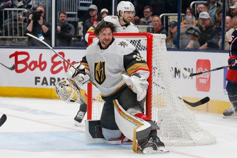 Mar 4, 2024; Columbus, Ohio, USA; Vegas Golden Knights goalie Adin Hill (33) loses his mask after making a save on a Columbus Blue Jackets shot attempt during the second period at Nationwide Arena. Mandatory Credit: Russell LaBounty-USA TODAY Sports