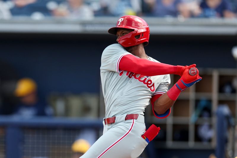 Mar 7, 2024; Port Charlotte, Florida, USA;  Philadelphia Phillies center fielder Johan Rojas (18) doubles against the Tampa Bay Rays in the seventh inning at Charlotte Sports Park. Mandatory Credit: Nathan Ray Seebeck-USA TODAY Sports