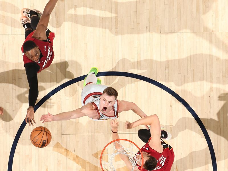 DENVER, CO - JUNE 12: Bam Adebayo #13 of the Miami Heat and Christian Braun #0 of the Denver Nuggets go for the rebound during Game Five of the 2023 NBA Finals on June 12, 2023 at Ball Arena in Denver, Colorado. NOTE TO USER: User expressly acknowledges and agrees that, by downloading and or using this Photograph, user is consenting to the terms and conditions of the Getty Images License Agreement. Mandatory Copyright Notice: Copyright 2023 NBAE (Photo by Nathaniel S. Butler/NBAE via Getty Images)