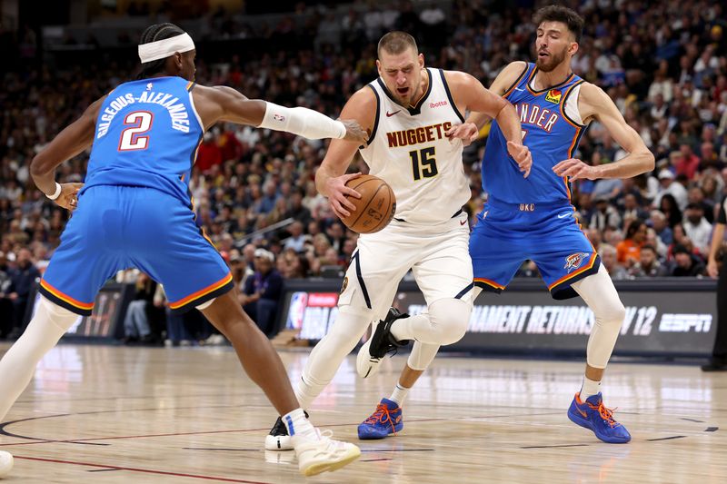 DENVER, COLORADO - OCTOBER 24: Nikola Jokic #15 of the Denver Nuggets drives against Shai Gilgeous-Alexander #2 and Chet Holmgren #7 of the Oklahoma City Thunder in the first quarter at Ball Arena on October 24, 2024 in Denver, Colorado. NOTE TO USER: User expressly acknowledges and agrees that, by downloading and or using this photograph, User is consenting to the terms and conditions of the Getty Images License Agreement. (Photo by Matthew Stockman/Getty Images)