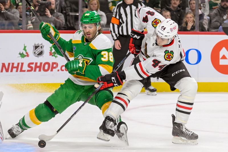 Nov 29, 2024; Saint Paul, Minnesota, USA;  Minnesota Wild forward Ryan Hartman (38) is called for trip[ping on this play with Chicago Blackhawks defenseman Wyatt Kaiser (44) during the second period at Xcel Energy Center. Mandatory Credit: Nick Wosika-Imagn Images