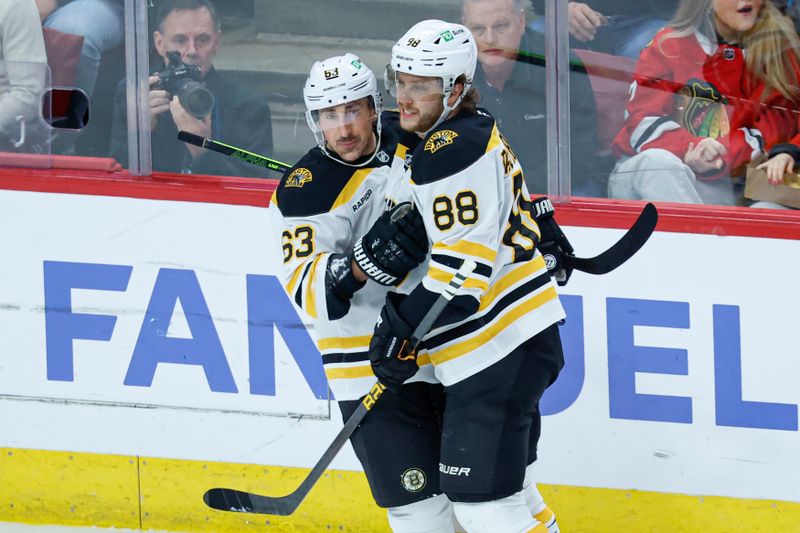 Dec 4, 2024; Chicago, Illinois, USA; Boston Bruins left wing Brad Marchand (63) celebrates with right wing David Pastrnak (88) after scoring against the Chicago Blackhawks during the second period at United Center. Mandatory Credit: Kamil Krzaczynski-Imagn Images