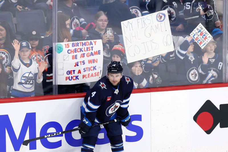 Feb 25, 2024; Winnipeg, Manitoba, CAN;  Winnipeg Jets defenseman Neal Pionk (4) takes a break during warm up before a game against the Arizona Coyotes at Canada Life Centre. Mandatory Credit: James Carey Lauder-USA TODAY Sports