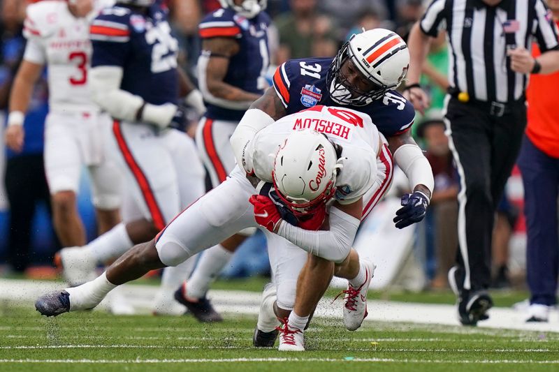 Dec 28, 2021; Birmingham, Alabama, USA; Auburn Tigers linebacker Chandler Wooten (31) tackles Houston Cougars wide receiver Jake Herslow (87) during the second half of the 2021 Birmingham Bowl at Protective Stadium. Mandatory Credit: Marvin Gentry-USA TODAY Sports